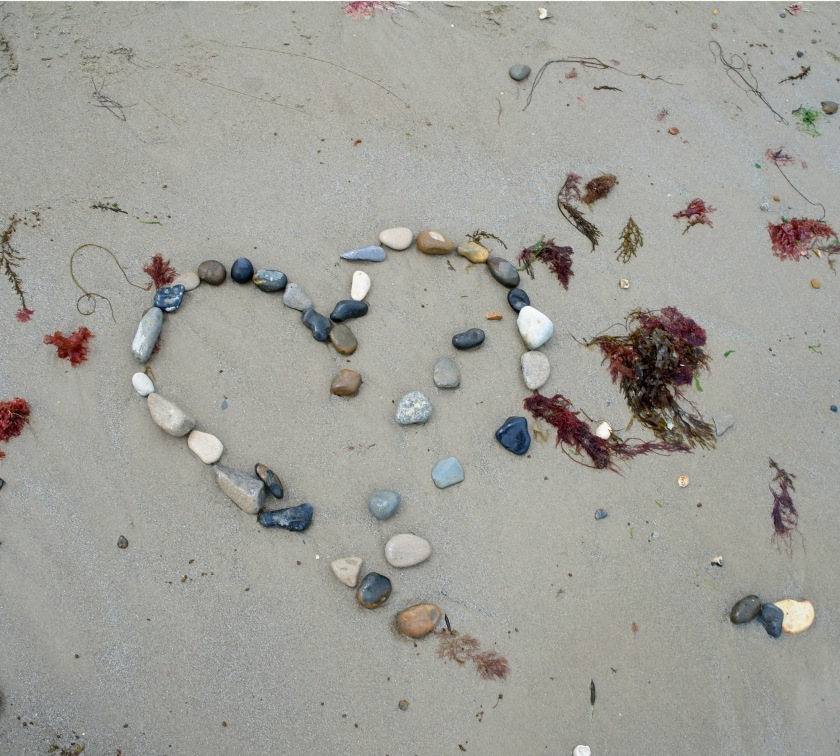 Partially washed away heart made of pebbles on the beach at Swanage, Dorset. Beach art. Stone and pebble heart.